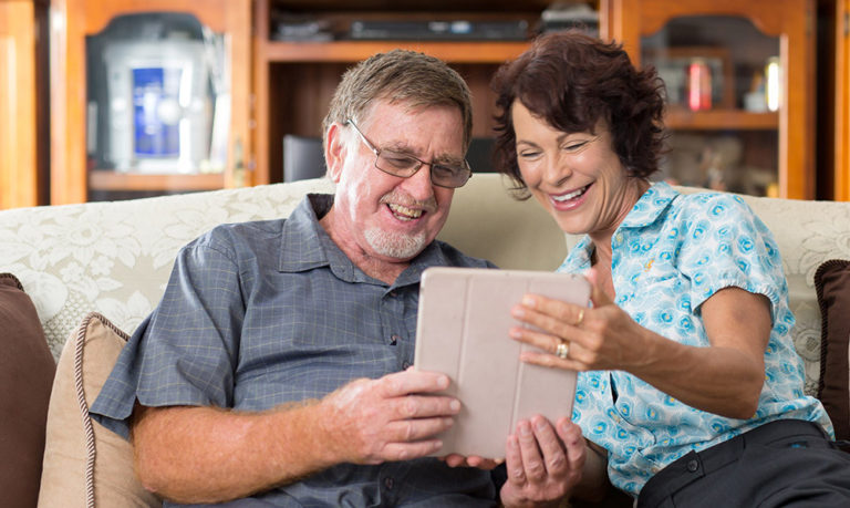 IRT staff member assisting elderly man with technology