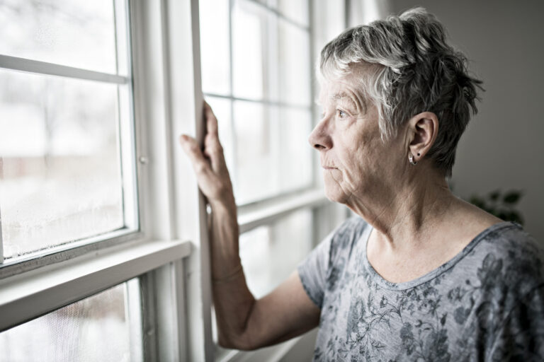 Older woman looking out window